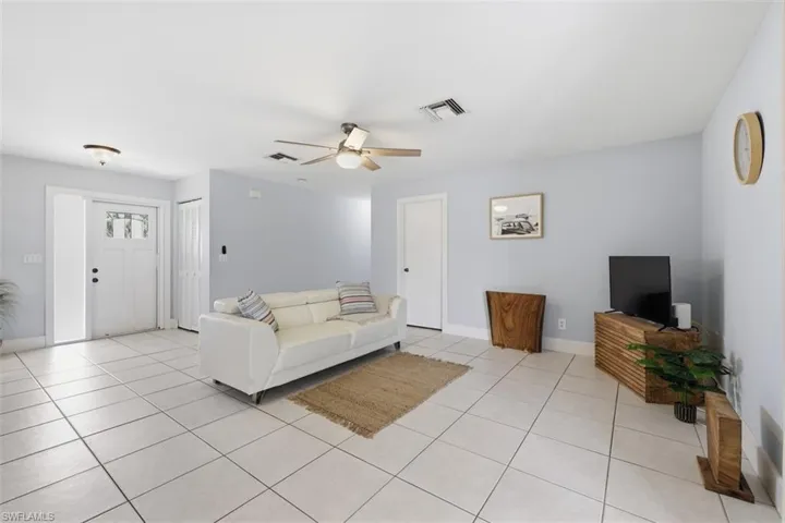 Living area featuring ceiling fan and light tile patterned floors