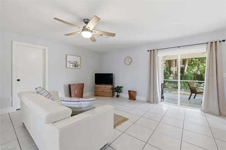 Living area featuring a ceiling fan and light tile patterned flooring