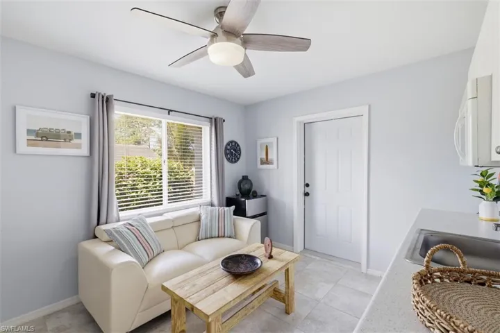 Living area featuring ceiling fan and light tile patterned flooring
