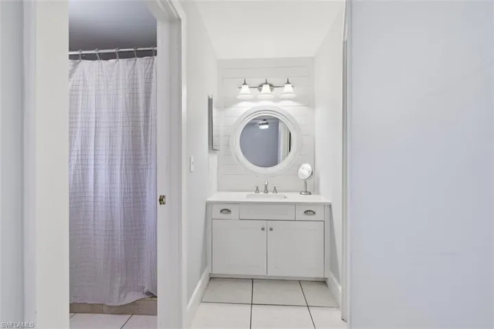 Full bathroom with a shower with curtain, vanity, and light tile patterned floors