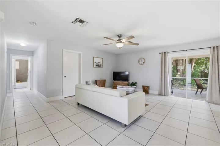 Living area with ceiling fan and light tile patterned floors