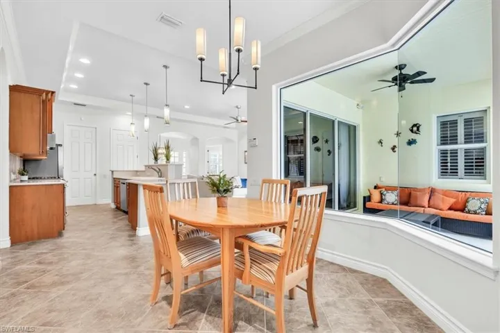 Dining area featuring a contemporary chandelier and bay window overlooking the patio
