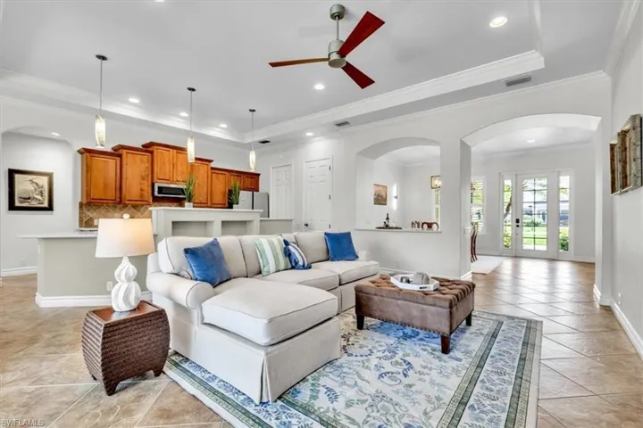Spacious living area featuring coffered ceilings, recessed lighting, and large format tile flooring