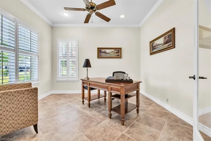 Interior room featuring large windows with white plantation shutters, tile flooring, recessed lighting, crown molding, and a ceiling fan with light fixture
