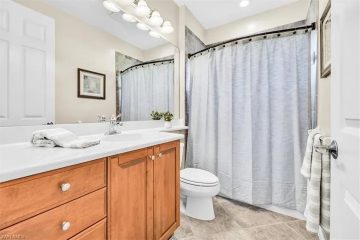 Bathroom featuring a light wood-finish vanity with a white countertop and integrated sink