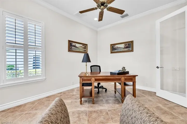 Interior room featuring tile flooring, white baseboards, and crown molding