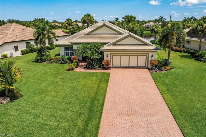 Single story home featuring stucco siding, an attached garage, decorative driveway, and a front yard