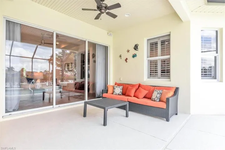 Covered patio featuring a ceiling fan, light-toned exterior walls, and a textured concrete floor