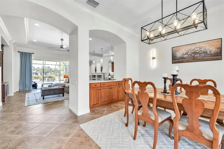Dedicated dining area featuring a linear chandelier, recessed lighting, and a wall-mounted sconce