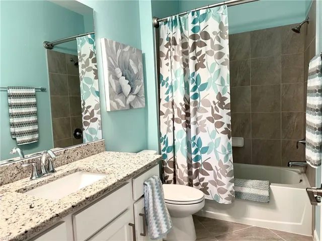 Bathroom 2 featuring granite counter, tile flooring, and shower / bathtub combination.