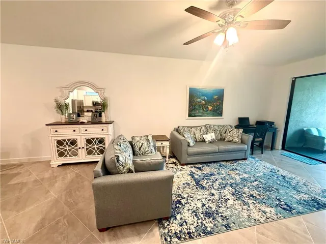 Living room featuring ceiling fan and light with tile floors