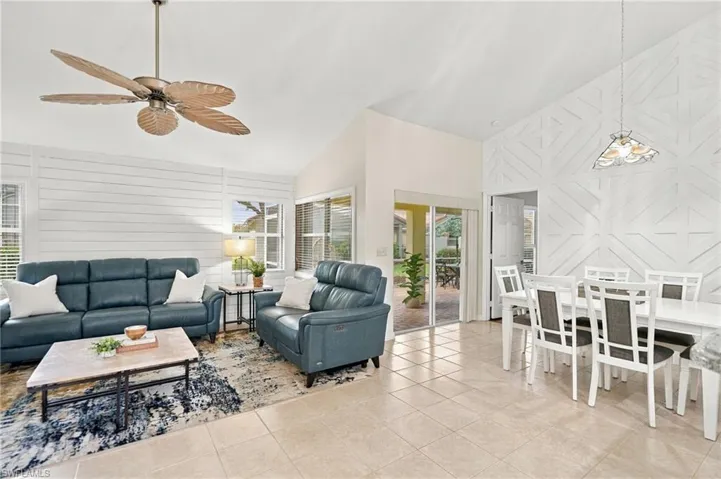 Vaulted ceilings, tile flooring, and sliding glass doors to the exterior