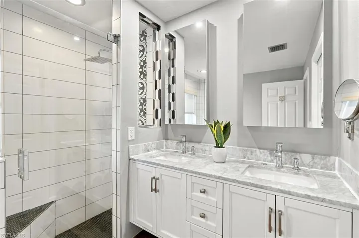 Dual vanity with undermount sinks, stone countertops, and chrome fixtures