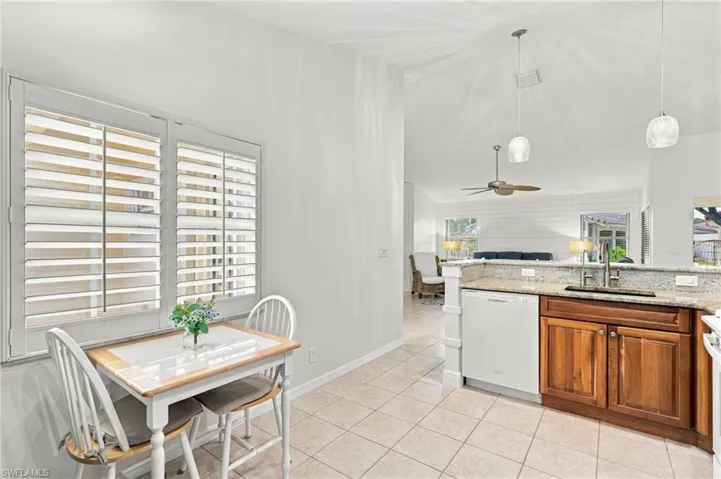 Kitchen featuring wood-finish cabinetry, light-toned countertop, and tile flooring