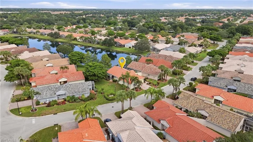 Residential neighborhood featuring mature landscaping, a central water feature, and a variety of roof styles