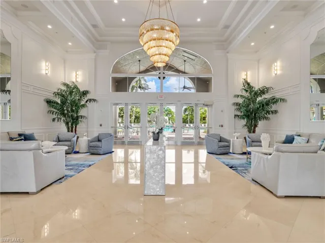High-volume ceiling with ornate chandelier and recessed lighting