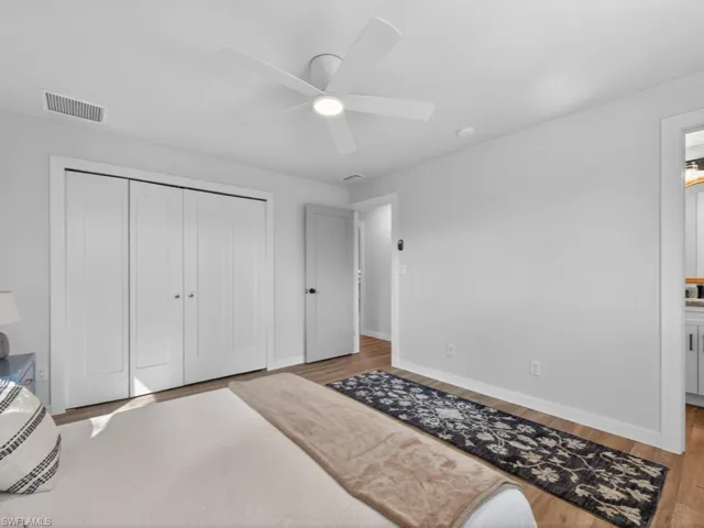 Primary Bedroom with a closet, wood finished floors, connected bathroom, and a ceiling fan