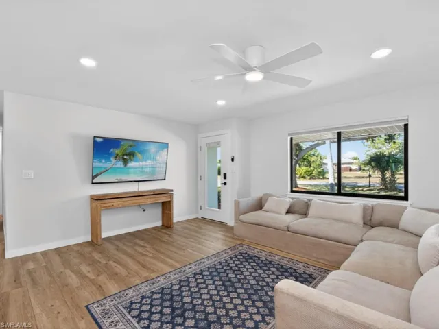 Living area featuring wood finished floors, a ceiling fan, and recessed lighting