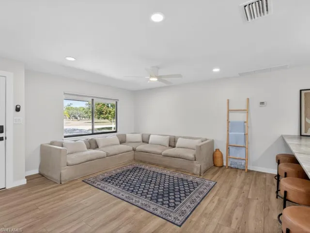 Living area featuring light wood-style flooring, a ceiling fan, and recessed lighting