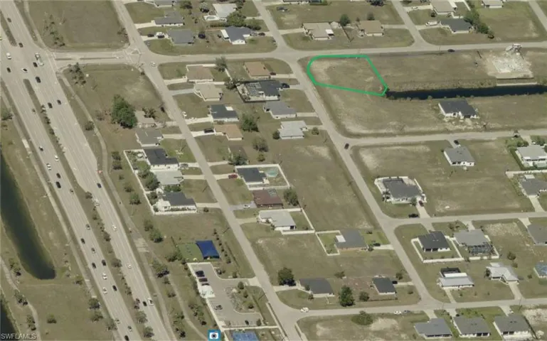 Aerial view of property and surrounding area featuring property parcel outlined