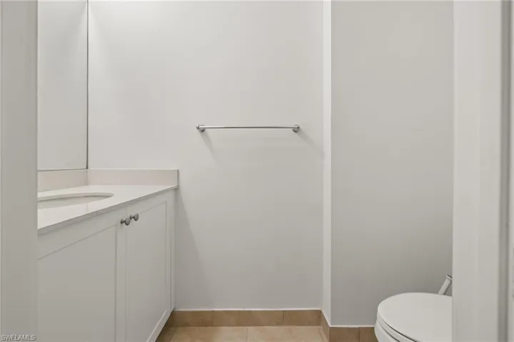 Bathroom with toilet, vanity, and tile patterned floors