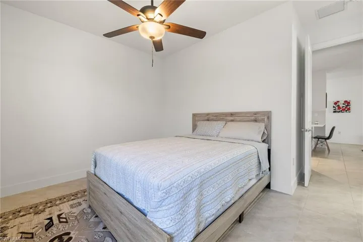 Tiled bedroom featuring ceiling fan