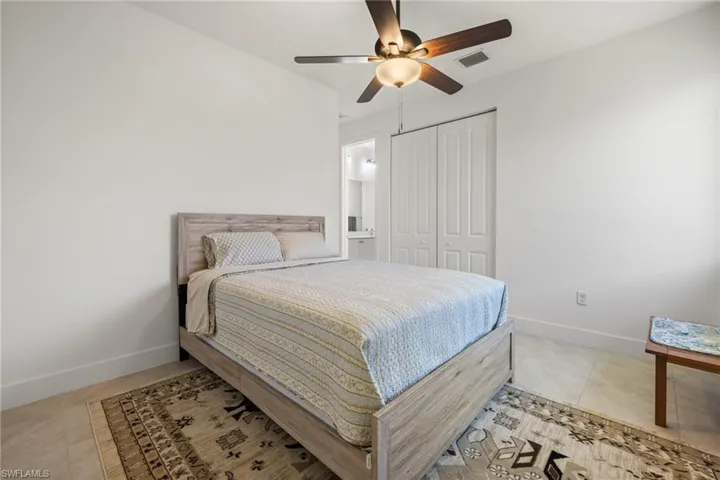 Tiled bedroom featuring a closet and ceiling fan