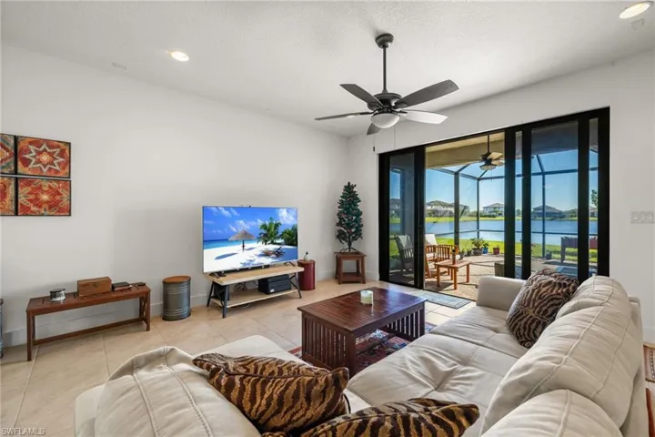 Tiled living room featuring ceiling fan and a textured ceiling