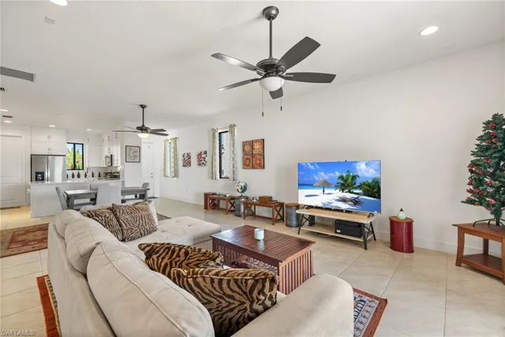 Living room featuring light tile patterned floors and ceiling fan