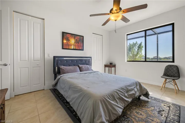 Bedroom featuring multiple closets, ceiling fan, and light tile patterned flooring