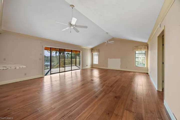 Unfurnished living room featuring lofted ceiling, hardwood / wood-style floors, and ceiling fan