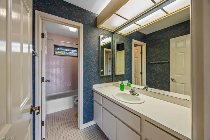 Bathroom featuring vanity, tile patterned floors, and toilet