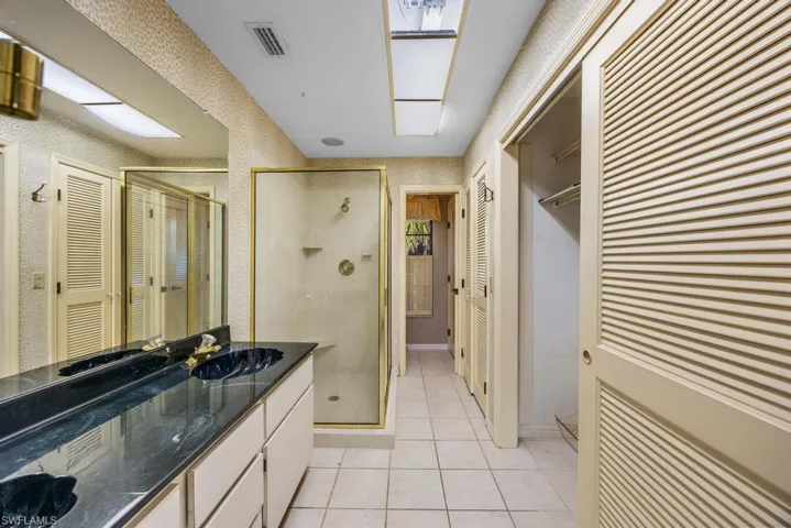 Bathroom with tile patterned floors, an enclosed shower, and vanity