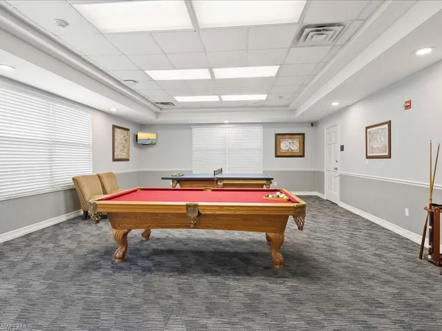 Recreational room featuring patterned carpet flooring, recessed lighting, and a white paneled ceiling