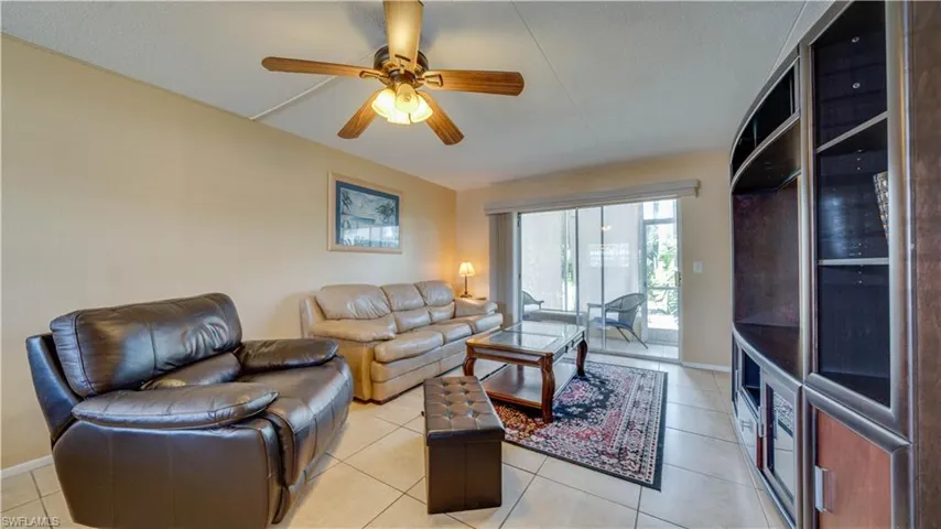Living room featuring ceiling fan, light tile patterned flooring