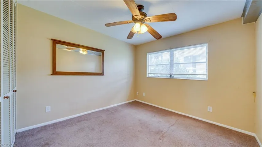 Unfurnished room with ceiling fan and light carpet