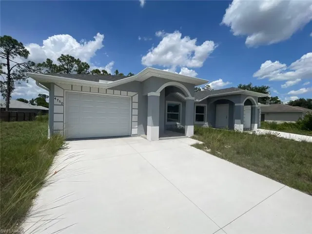 Ranch-style house featuring a garage, concrete driveway, and stucco siding