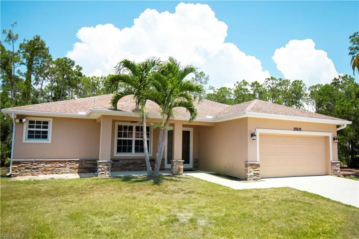 View of front of property featuring a front lawn and a garage
