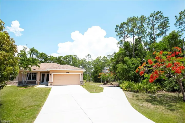 View of front of property with a garage and a front yard
