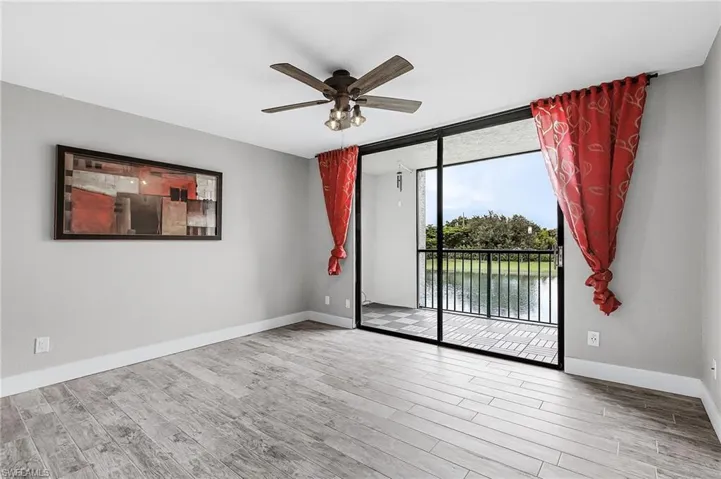 Unfurnished room featuring floor to ceiling windows, light wood-style flooring, and a ceiling fan