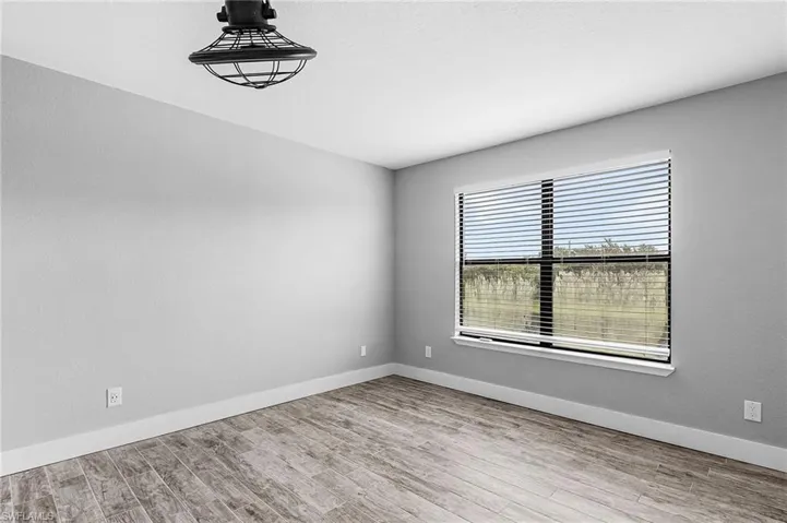 Spare room with baseboards and light wood finished floors