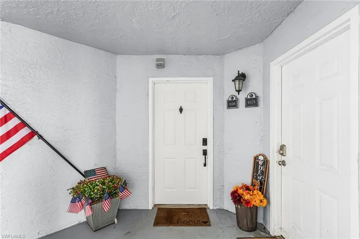 Doorway to property featuring stucco siding