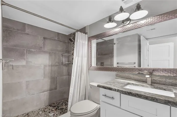 Bathroom with vanity and a tile shower