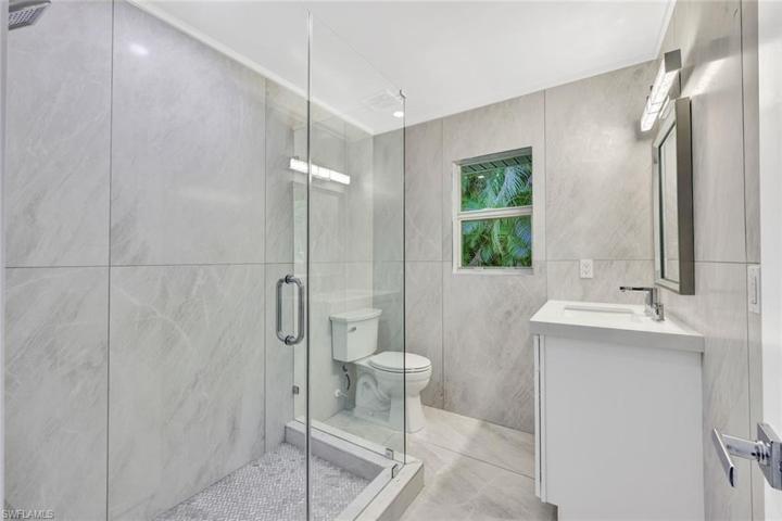 Gorgeous guest bathroom with walk-in shower and floor to ceiling decorative tile.