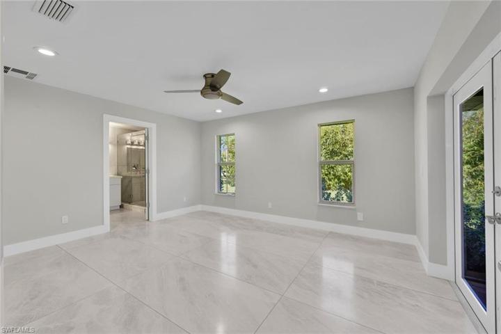 Privately tucked away, the serene primary suite, complete w/access to the pool area, features a spacious, sunny bedroom with stunning flooring.