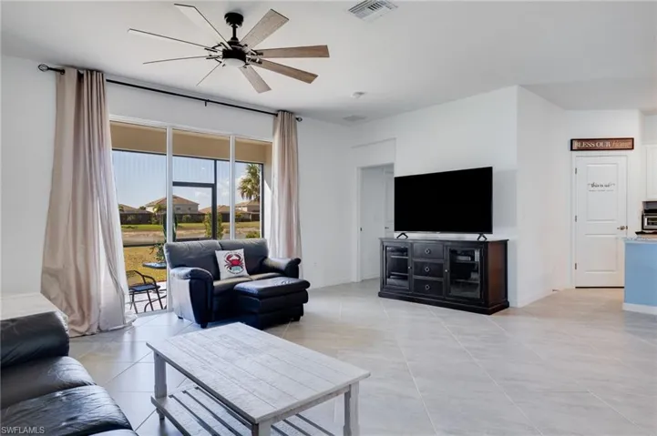 Living area featuring ceiling fan and light tile patterned floors