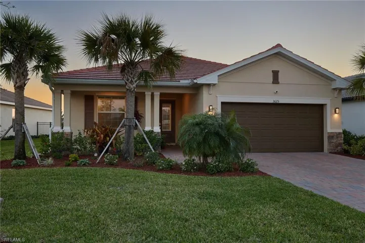 Ranch-style house featuring stucco siding, decorative driveway, stone siding, and a garage