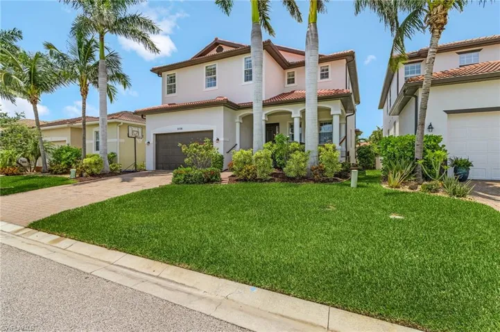 Mediterranean / spanish house with driveway, stucco siding, a front lawn, an attached garage, and covered porch