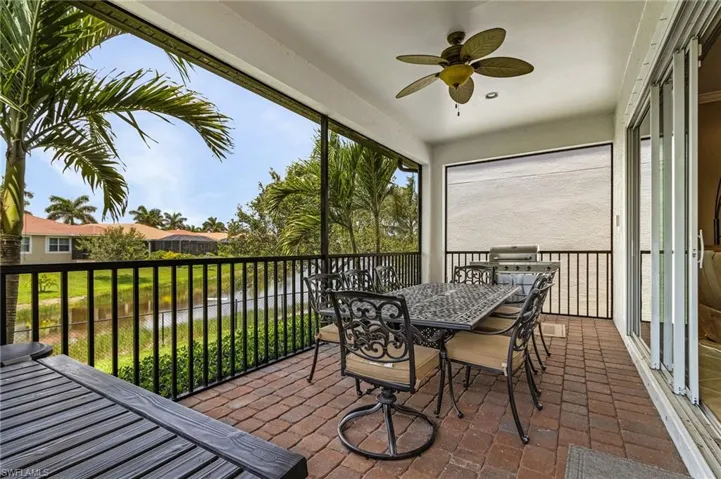 Sunroom featuring a water view, a ceiling fan, and outdoor dining area