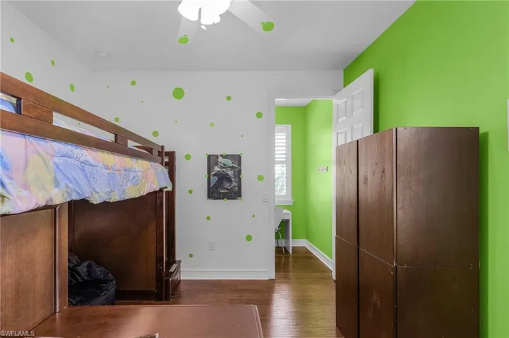 Bedroom with wood finished floors and baseboards